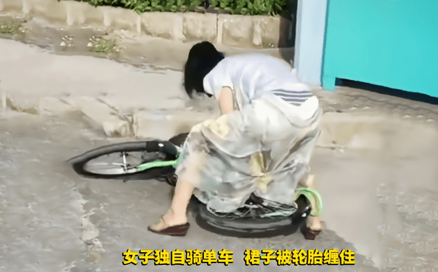 爱美 河北：女子骑单车，裙子被后轮缠住拽不出来，用力拉扯很尴尬