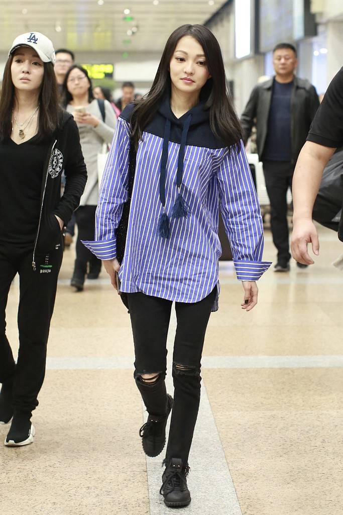 张韶涵现身机场穿拼接条纹卫衣配破洞牛仔裤双腿纤细抢镜