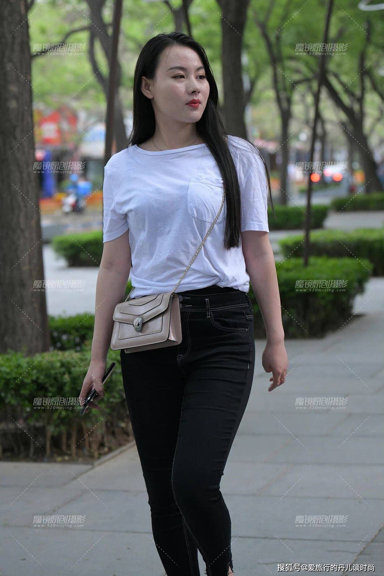 长发美女身穿简约的白色圆领t恤搭配黑色小脚牛仔裤大方又得体