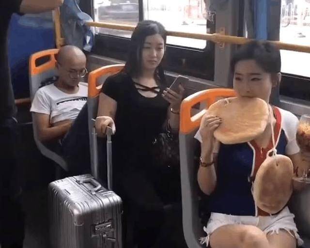 原创一年轻貌美女子在公交车上用高脚杯吃泡面脖子上还挂2大饼