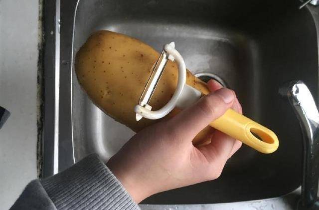 第一步:将用买肯德基"炸薯条"的钱买来的土豆洗净,然后用土豆挠将土豆