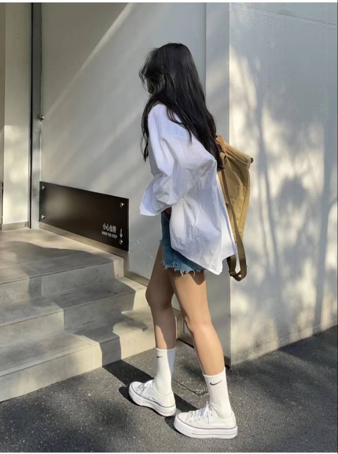 下半身搭配浅蓝色牛仔短裤,还穿了白色袜子和白色帆布鞋,一套青春靓丽