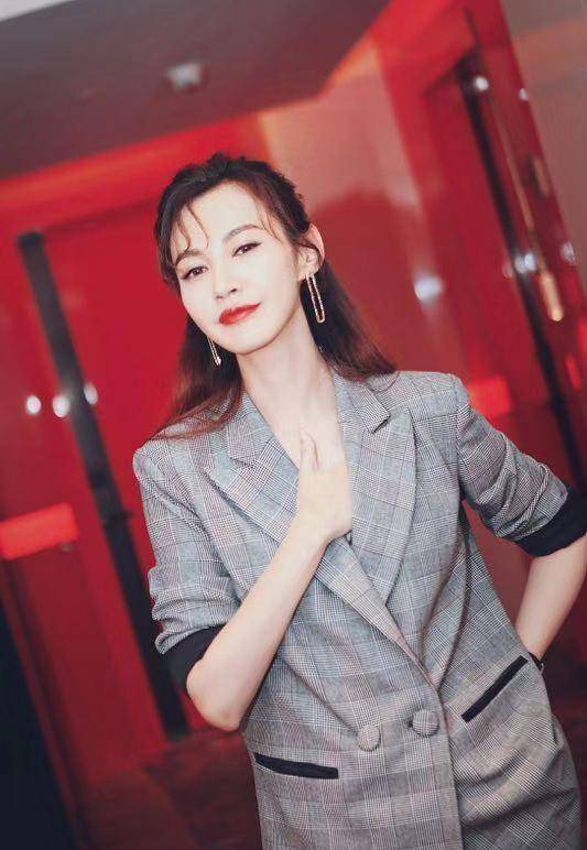 杨雪拍摄杂志时穿了一件黑色薄纱的连衣裙,外套了一件白色的西装,西装