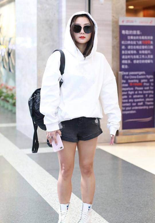 何洁穿国货走机场,白色卫衣配牛仔短裤暴露"小粗腿",真显胖_大气_气质