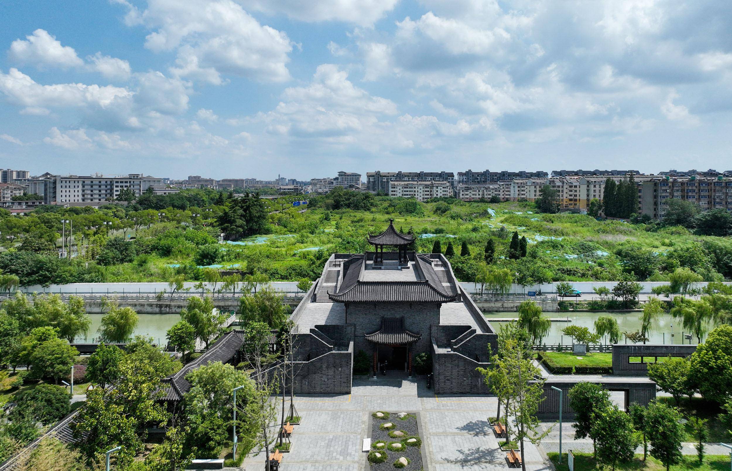 盛夏时节，在蓝天白云掩映下，扬州古运河水面光影闪烁如在画中游