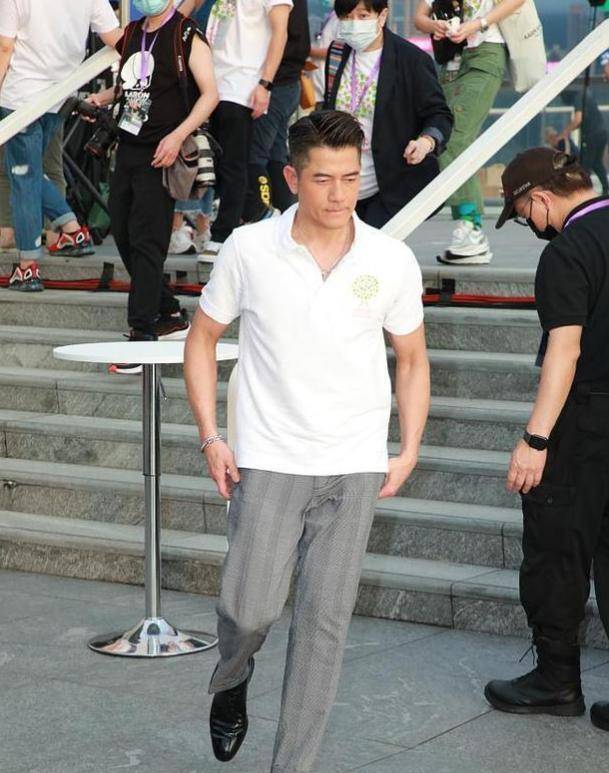 当天郭富城身穿一件白色polo衫,搭配竖条纹灰色西装裤,整体看起来潇洒