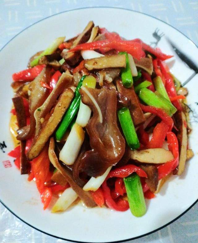 【豆腐干炒猪耳朵】所需食材及调料:猪耳朵,豆腐干,红辣椒,青大蒜