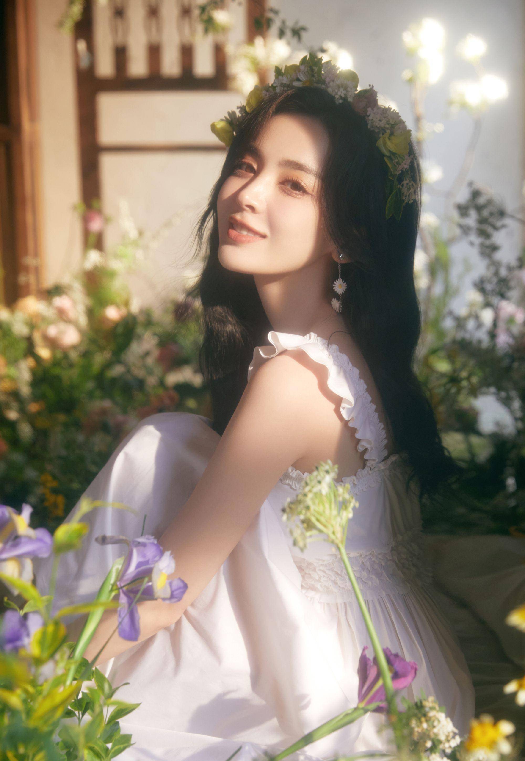 室晒出了一组生日写真,照片里娜扎身穿白色吊带连衣裙,披着微卷的长发