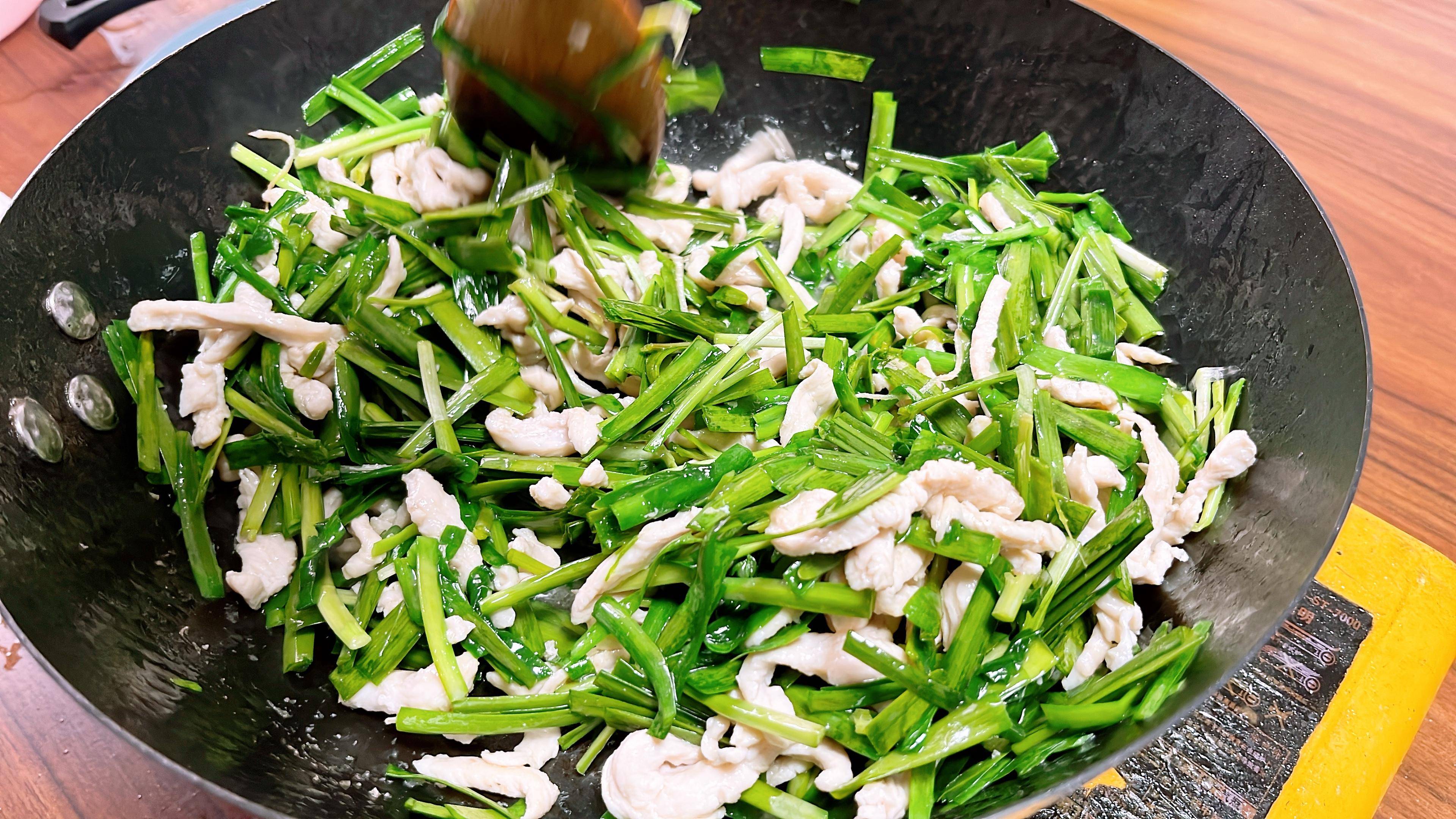 6,锅内再倒入一点油,油热后加入韭菜段炒制,适量的加一点盐调味,炒到