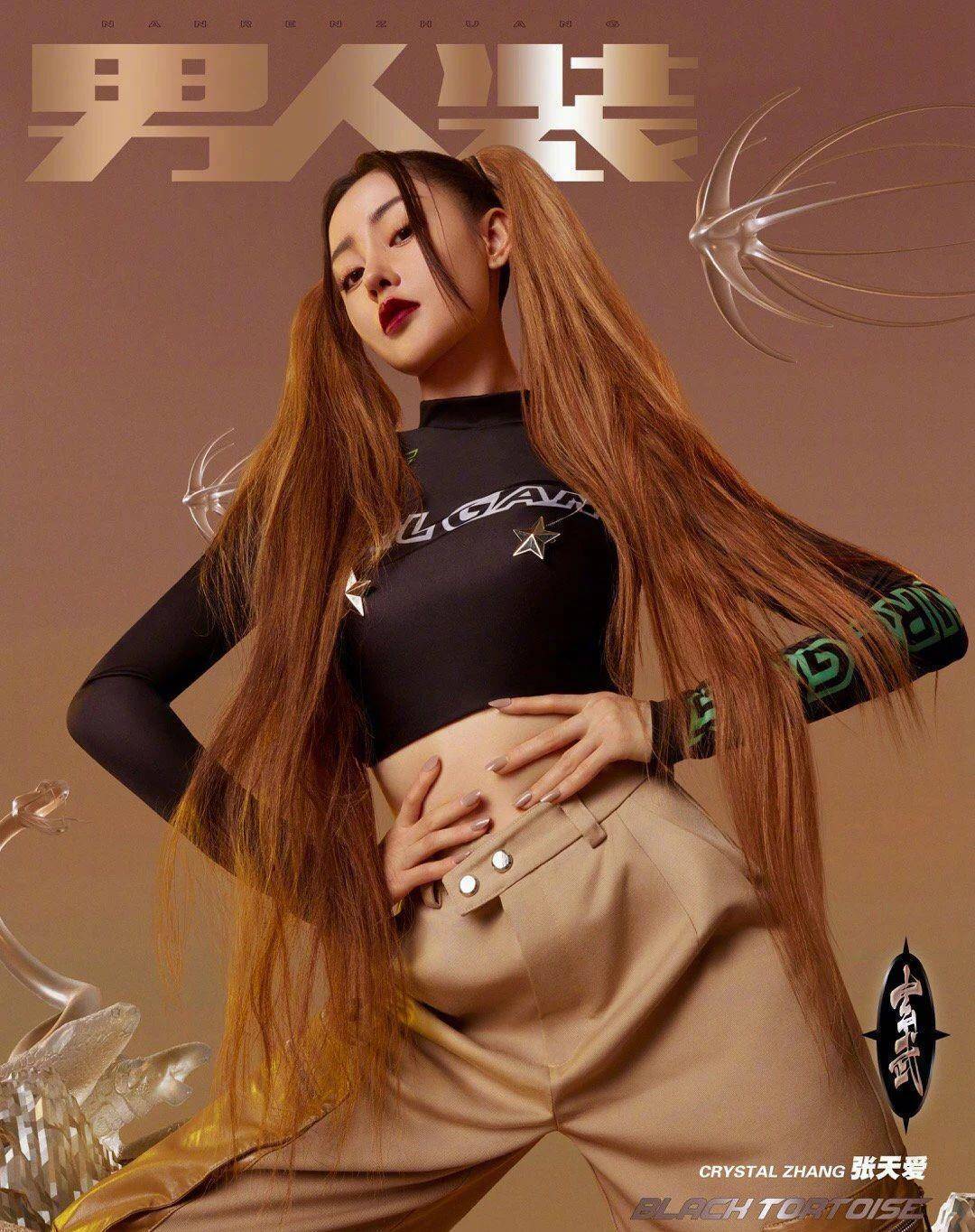 张天爱穿着紧身西装和泳衣,张开双臂单腿站立,展现出曼妙的腰臀曲线.