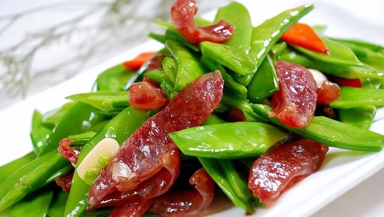 1,腊肉去掉老皮,然后切成硬币厚的片,接着荷兰豆撕去老根,对半切开,水