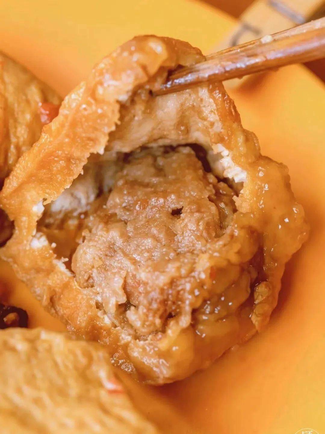 它有些像是豆腐皮版的饺子软软的腐皮里裹住了满满的肉丁笋干丁和