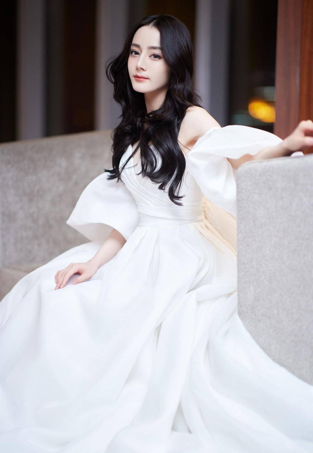 迪丽热巴晒雨中氛围感大片,一身白色泡泡裙清丽优雅,气质真好