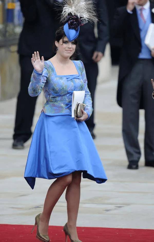 包括方领长袖绣花花上衣和一件不对称下摆的电蓝色喇叭中长裙