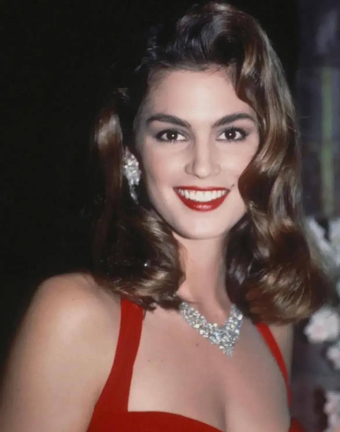 这是她1990年参加露华浓品牌活动时穿的造型,红色的挂脖紧身裙,金色的