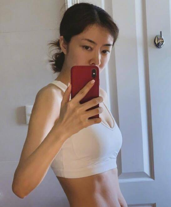 01照片中的熊黛林身穿白色紧身背心,尤其是凸显的马甲线,平坦的小腹