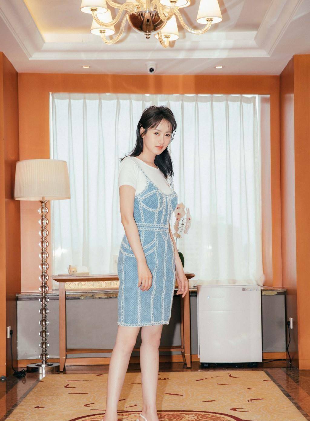 袁冰妍身穿白色t恤,外面套了件印花吊带裙,裙摆上的条纹装饰非常新颖