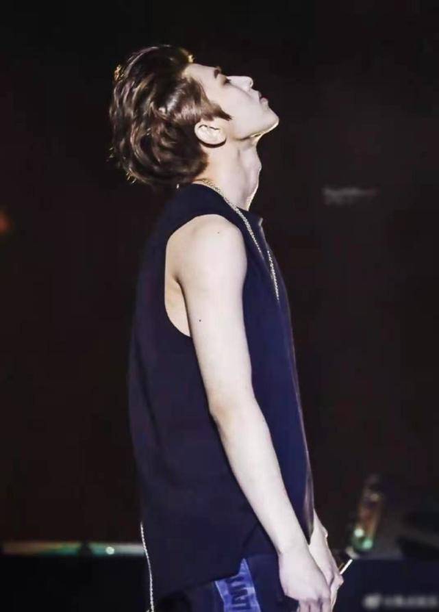 上半身只穿了一件老头式的白背心,衣服虽然简单,但是难掩蔡徐坤的帅气