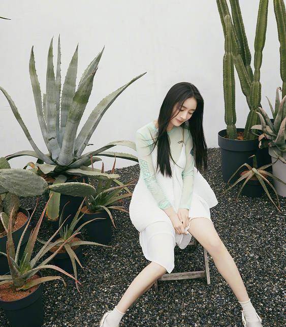 坐在椅子上拍照时,网友们注意到杨幂脚上穿着一双洞洞鞋.