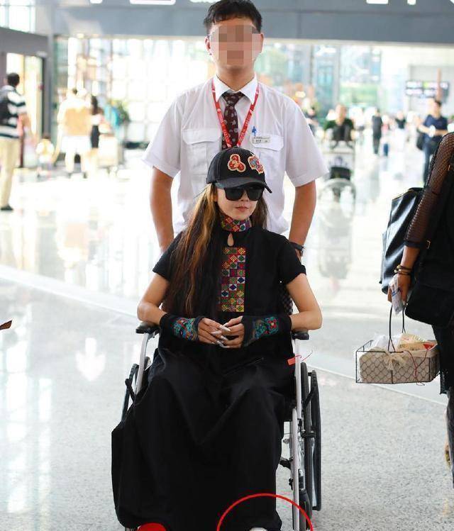 杨丽萍骨折后1个月现身机场,7厘米长指甲盖只能这个姿势玩手机_舞蹈