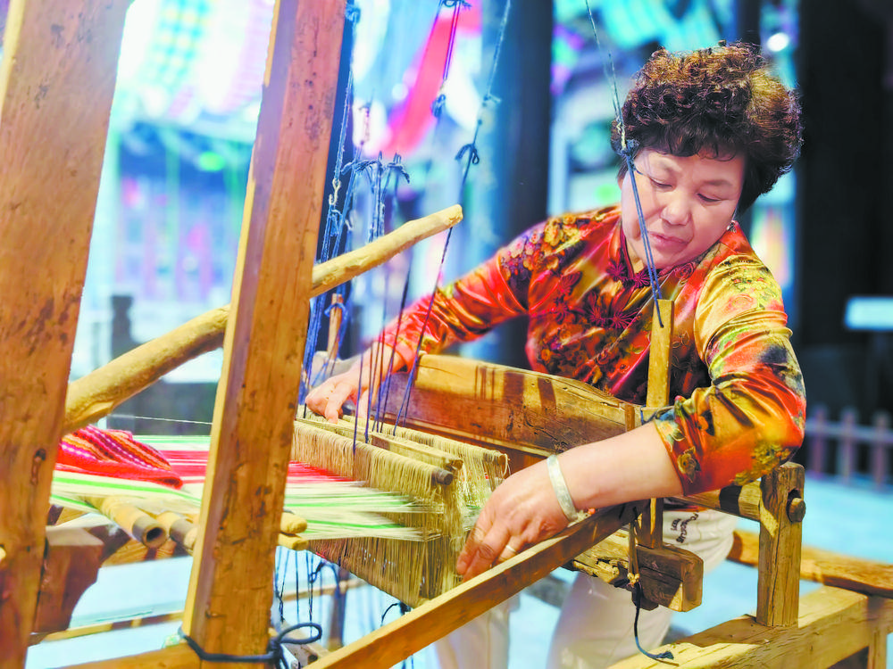 8月2日,在菏泽鲁锦文化展示体验中心,市民正在体验鲁锦制作技艺.