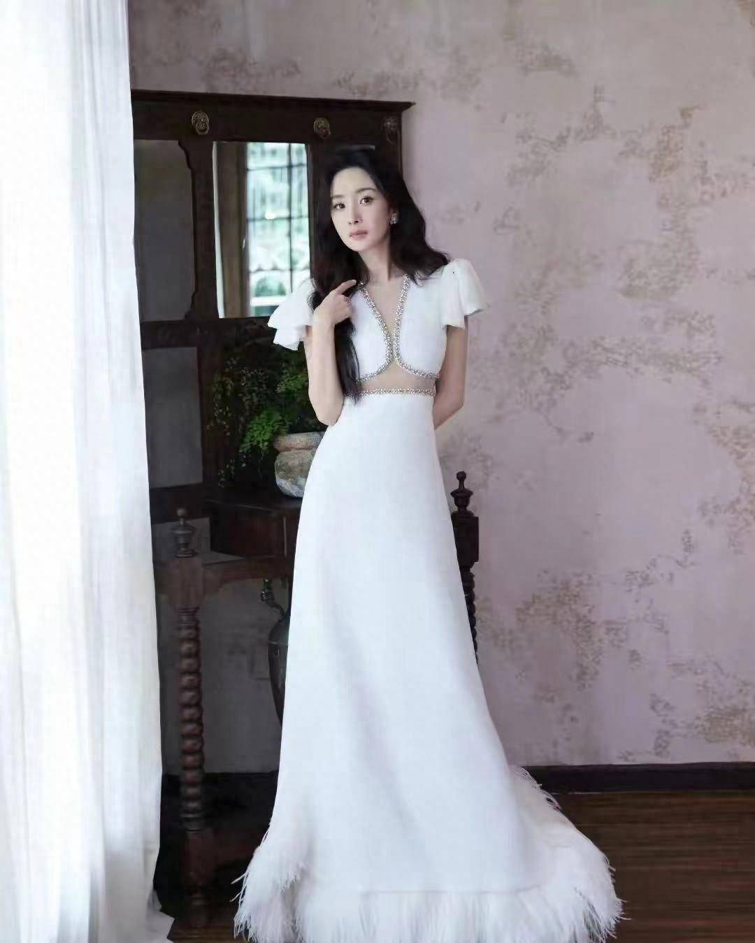 活动现场,杨幂身穿白色镶钻连衣裙,露腰.