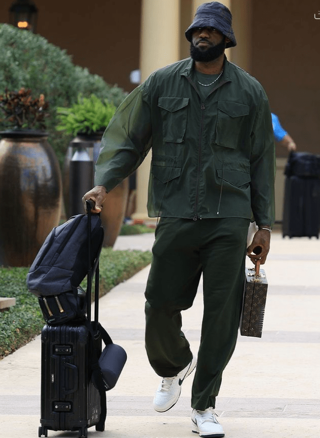 表情严肃,推着行李箱前往球馆;浓眉仅仅提着小包包,戴着墨镜搭配一身