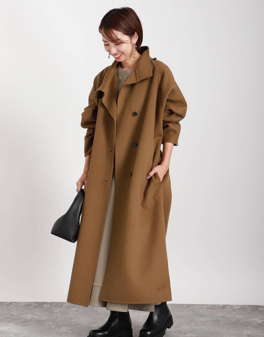 卡其色长款羊绒大衣,搭配浅灰色直筒羊毛连衣裙和漆皮感黑色厚底鞋.