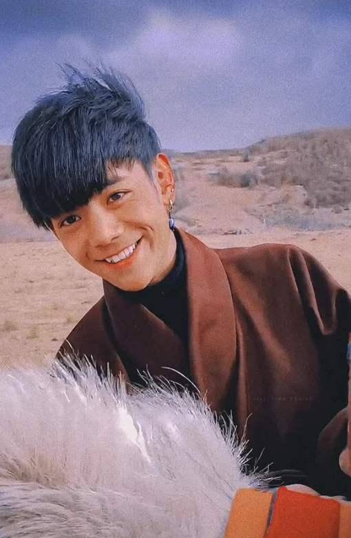 风把头发吹向一边,少年抿嘴一笑,对着镜头的眼神还是那么纯粹.