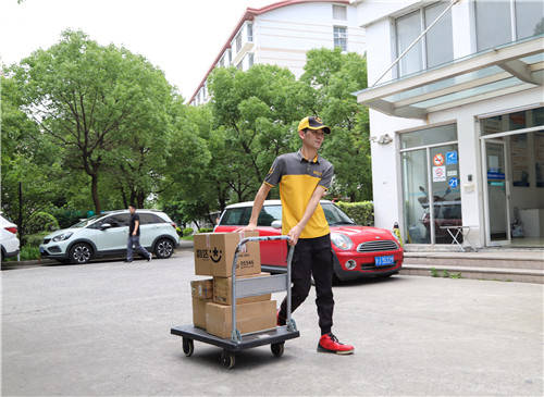 在活动现场,身穿韵达工装的工作人员有的在人流密集的公寓出入口发放