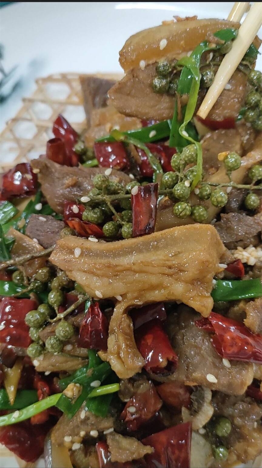 起锅烧水,待水烧开后小 保持水冒小泡下带皮牛肉,低温汤熟捞出装盘,撒