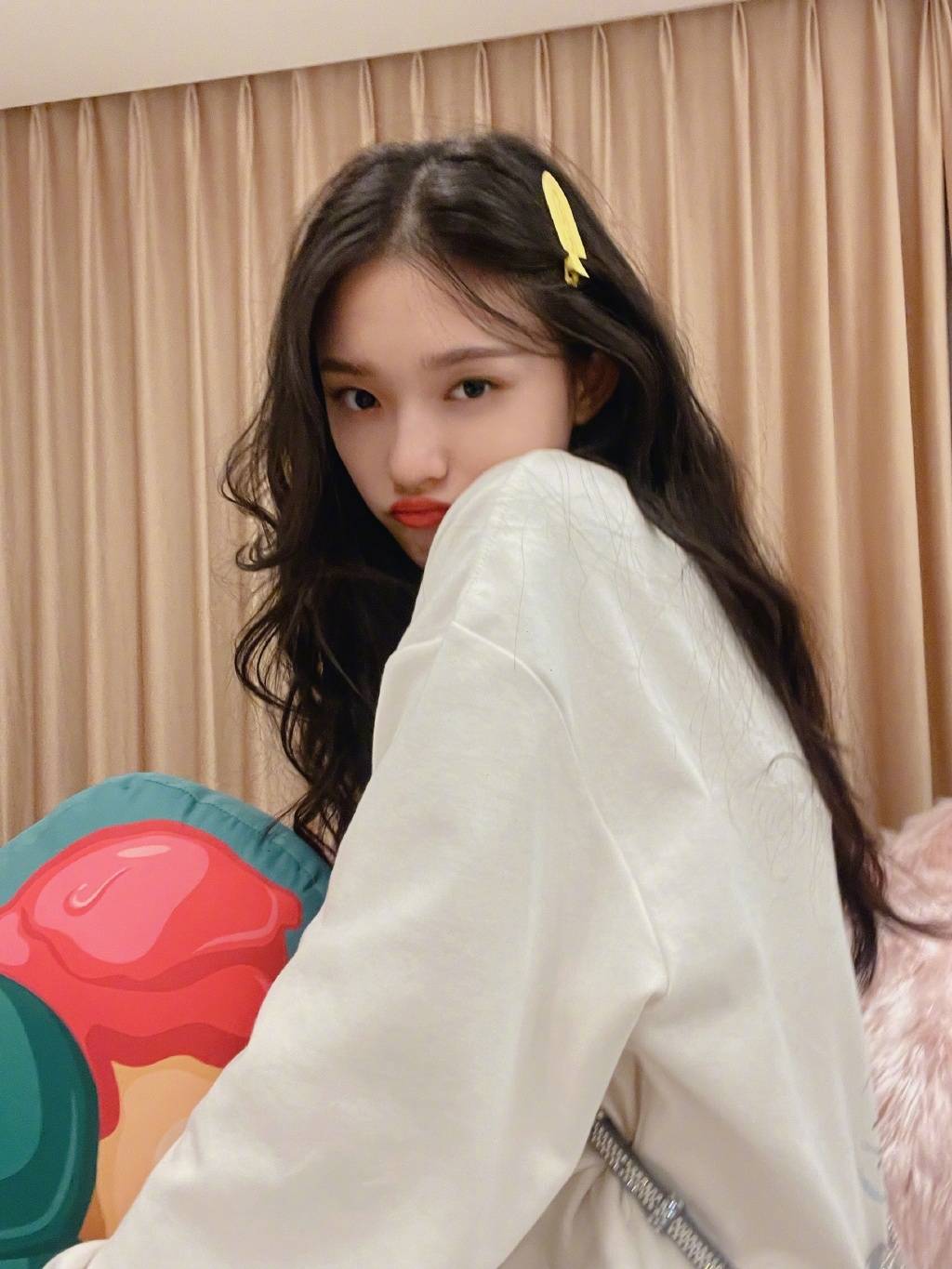 林允秀纤细长腿. 林允拿着抱枕挥舞姿态可爱. 林允笑容甜美.