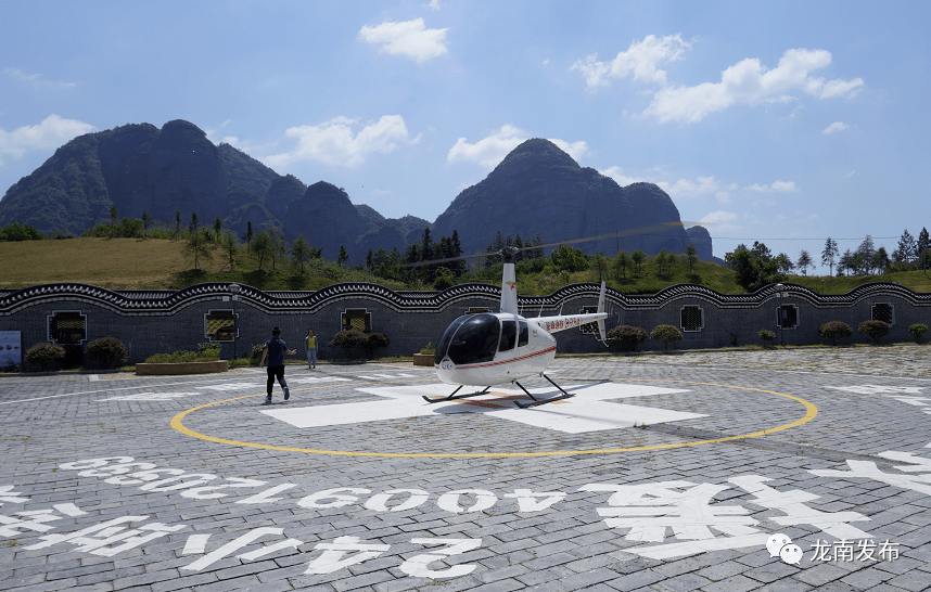 与会嘉宾观看直升机飞行表演,品尝龙南美食.