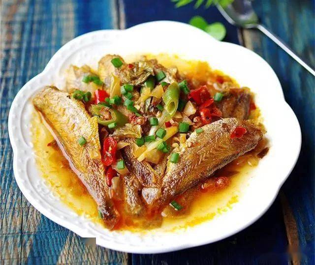 酸辣小黄鱼7,开盖加入盐稍加收汁即可,出锅装盘撒上小米椒.