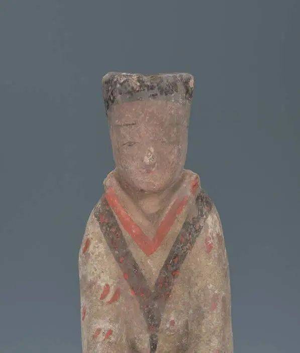 文物是一个立姿的侍女形象身穿三重衣,交领右衽曲裾绕身曳地呈喇叭状