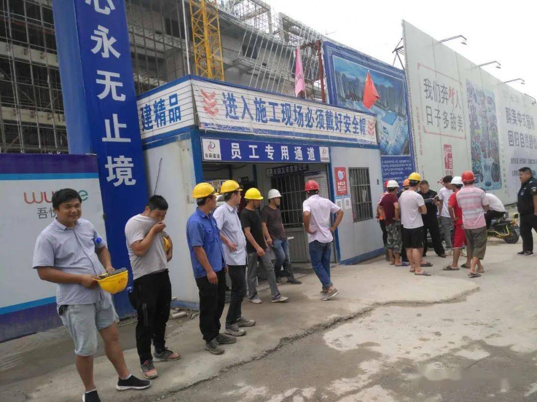 十多名头戴安全帽的工人围坐在工地项目部门前,一霎时工地进出受阻