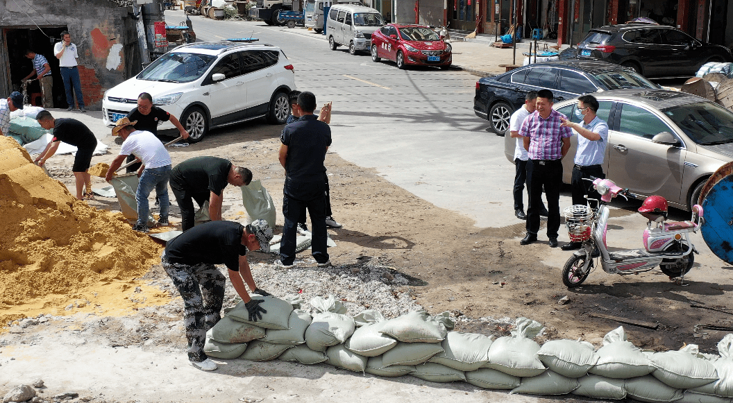 为防止海水倒灌,工作人员正用沙包在舥艚渔港码头低洼处筑起临时堤坝.