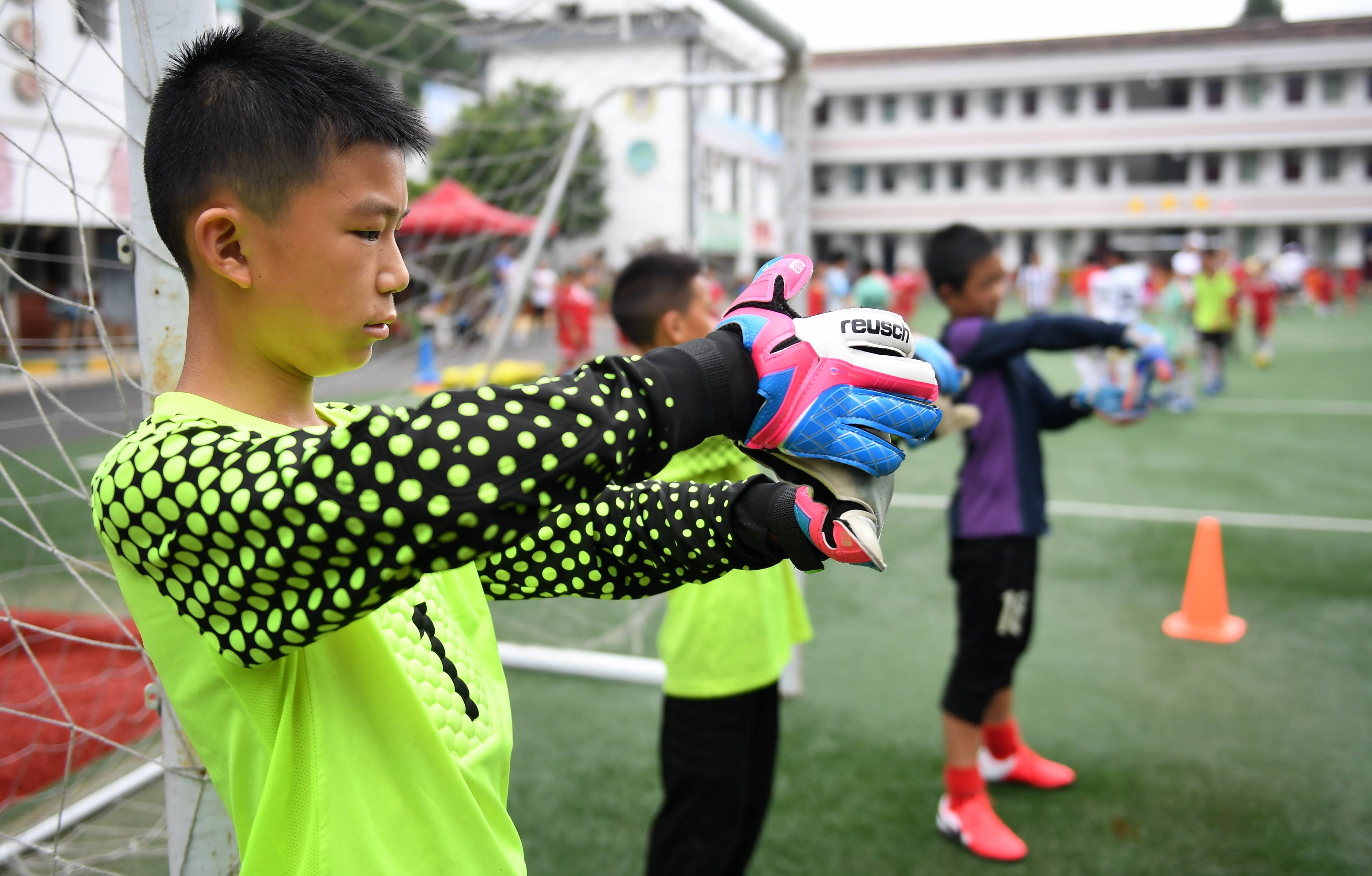 留坝县的小球员李旭尧(前)在位于秦岭南麓的武关驿镇中心小学进行足球