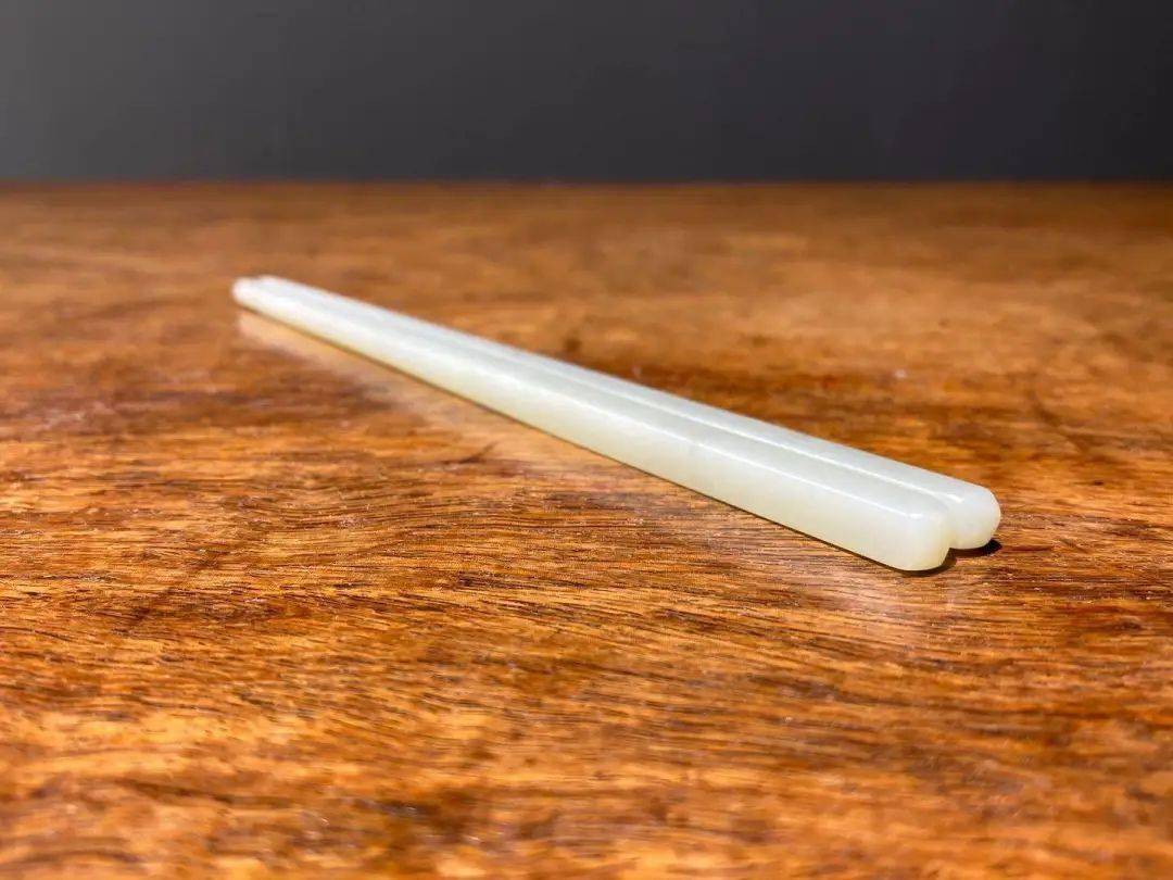 这是一双造型简约高雅,雕琢精致的和田籽料白玉筷子,色泽纯白略带灰青