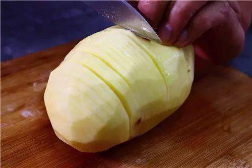 制作: 1, 用刀将土豆切成0.5cm的片,底部不要切断,切成风琴状.