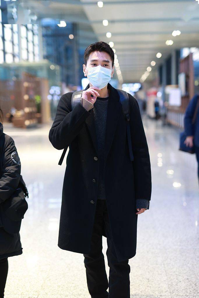 赵又廷背双肩包低调亮相机场 黑色大衣配小白鞋造型简约帅气
