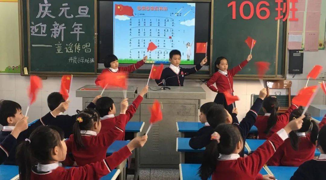 瞧,一年级的孩子们边演唱《国旗国旗真美丽》边挥动小五星红旗,把对