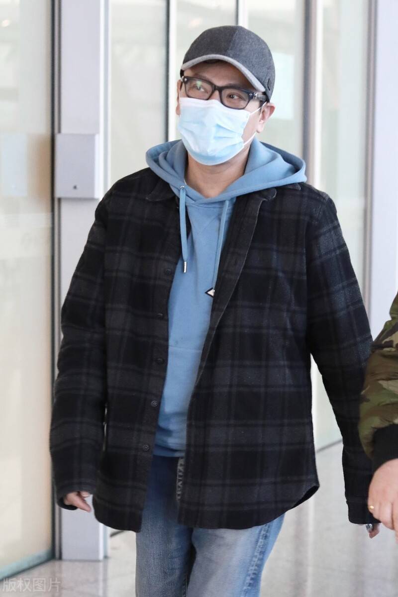 男神张信哲现身机场,蓝色卫衣配格外外套儒雅有气质