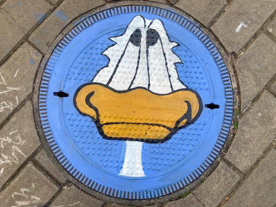 井盖涂鸦的美丽图案,色彩分明,十分醒目,突出,既有利于井盖的保护又能