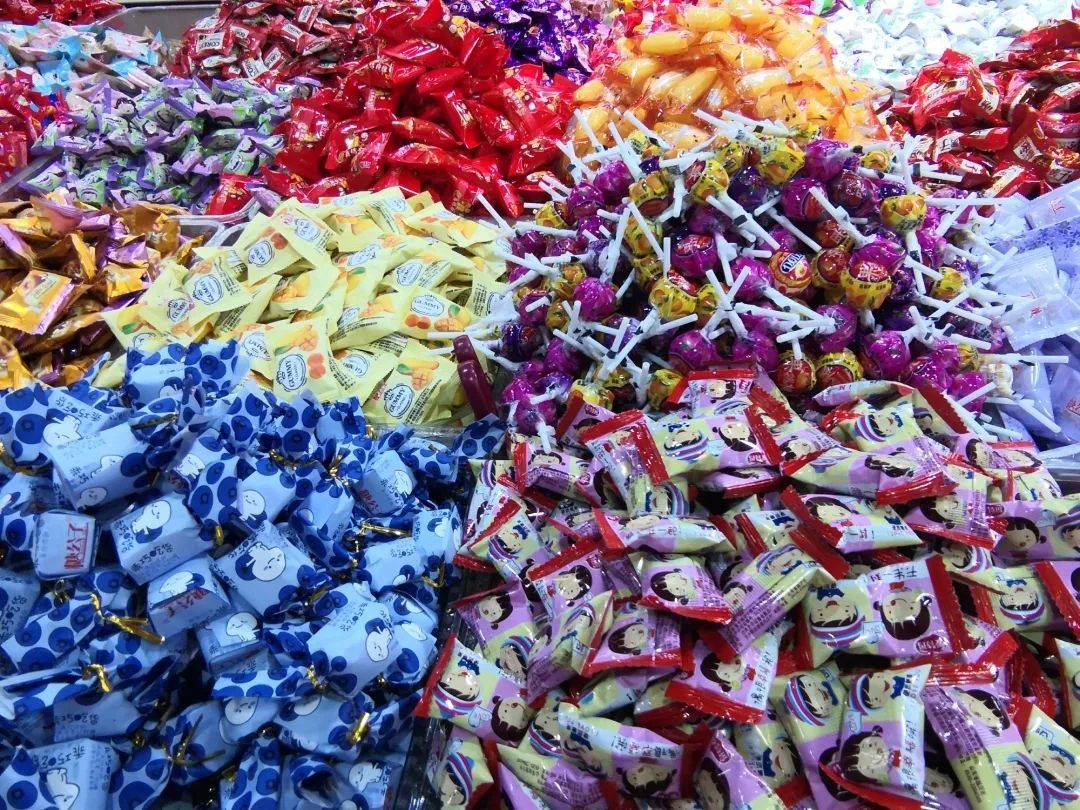 市场里售卖婚庆喜糖的店家居多,再加上年货商品的布置,更显喜气,一进