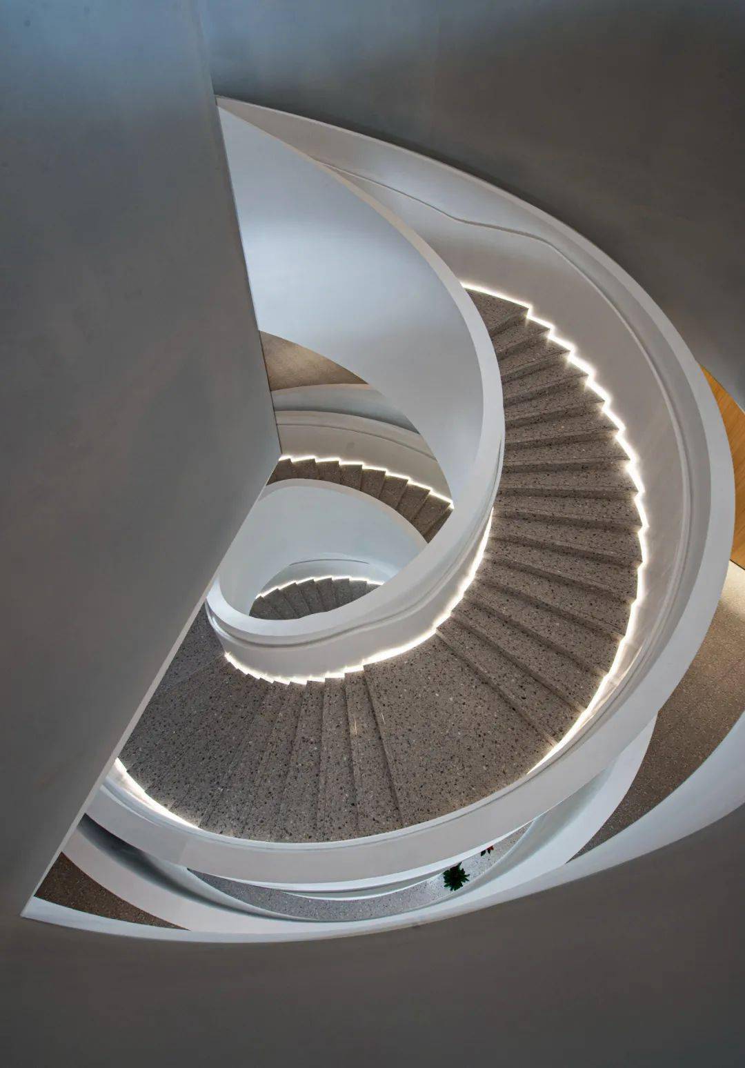 旋转楼梯在两侧背景灯光的衬托下,犹如漂浮的空中台阶,显得轻盈有趣