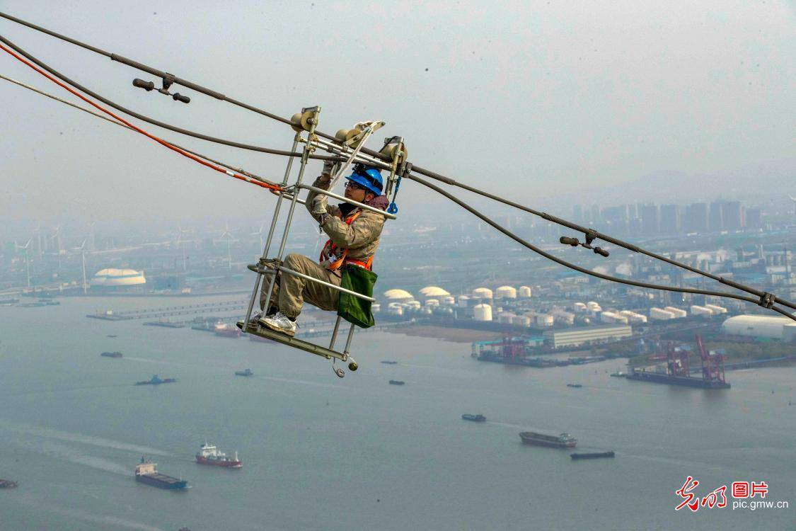 电力蜘蛛人对光缆阻尼线夹进行带电更换