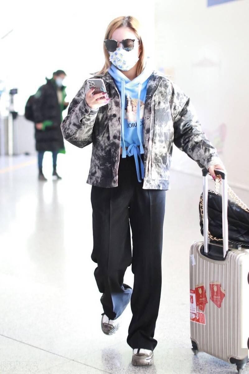 王菊穿印花羽绒服低调现身机场,面戴墨镜气质尽显