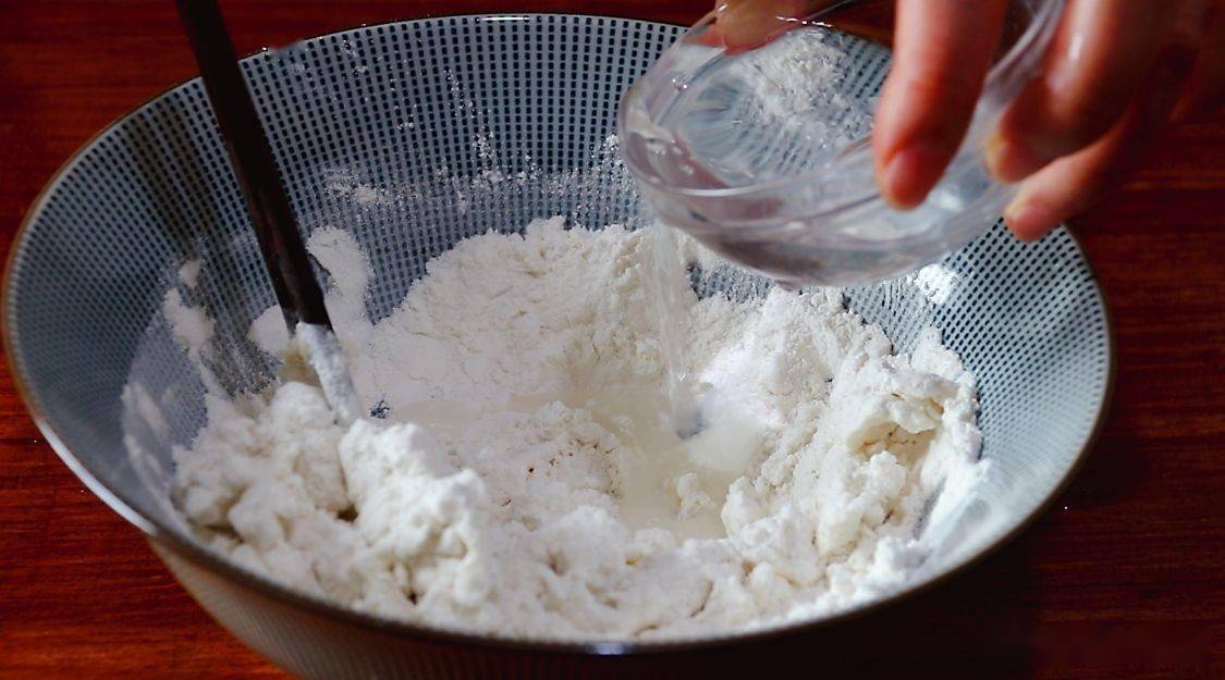 往大碗中加水,搅拌均匀,能把面粉揉成面团就可以了.