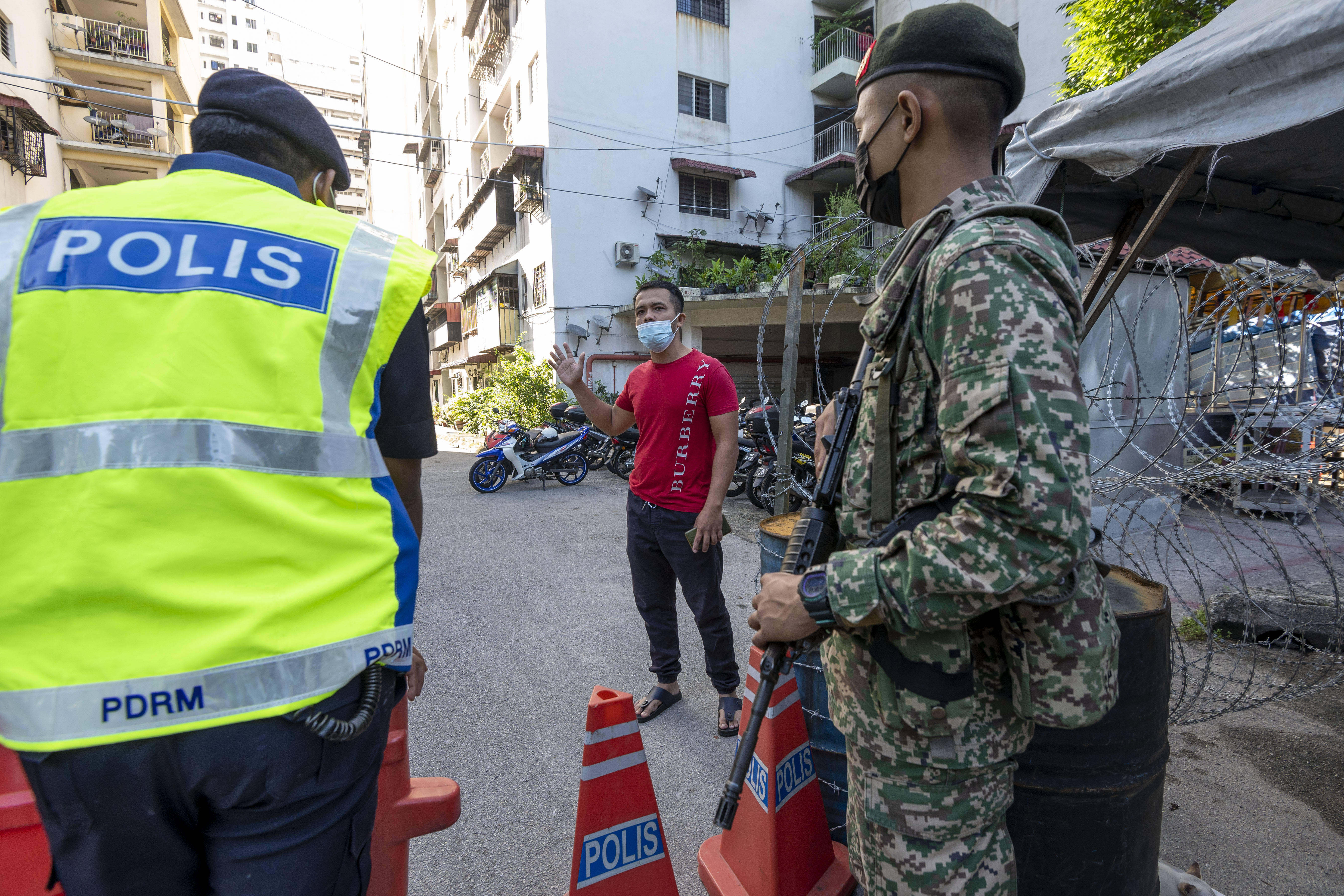 5月28日,警察和士兵在马来西亚吉隆坡市郊一处因新冠疫情被封锁的小区